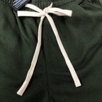 Stone Island green shorts with elastic waist, white drawcord ties, and stitched seams