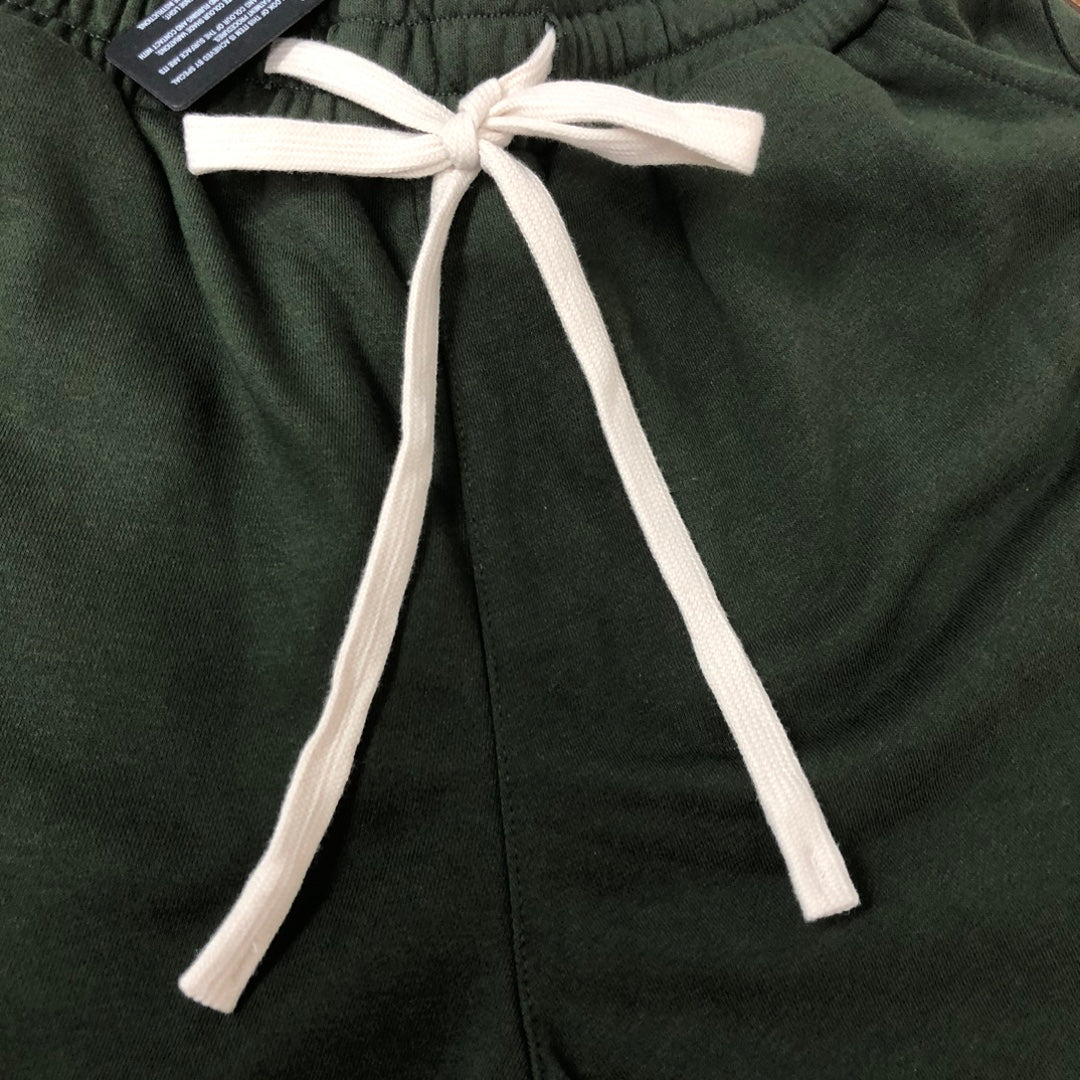 Stone Island green shorts with elastic waist, white drawcord ties, and stitched seams