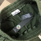 Stone Island green shorts showing inner label, elastic waistband, and care tag