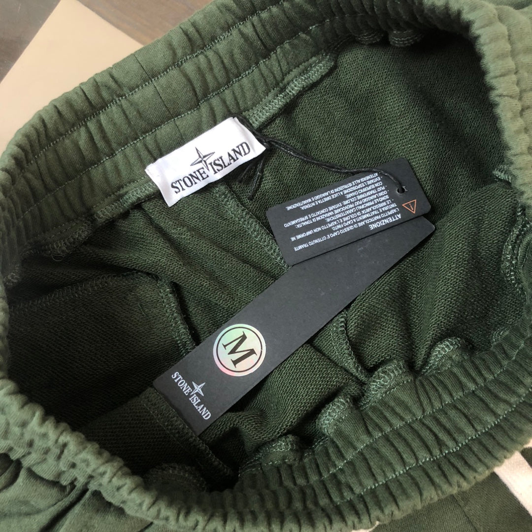 Stone Island green shorts showing inner label, elastic waistband, and care tag