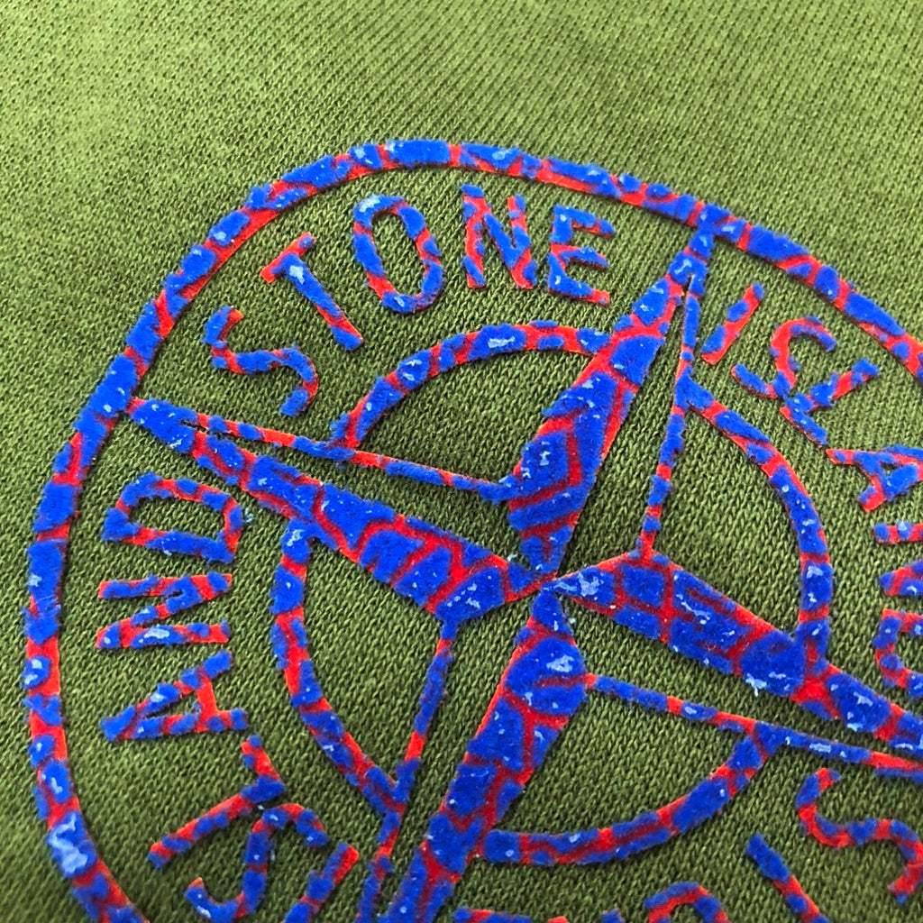 Close-up of blue logo embroidery on dark green shorts