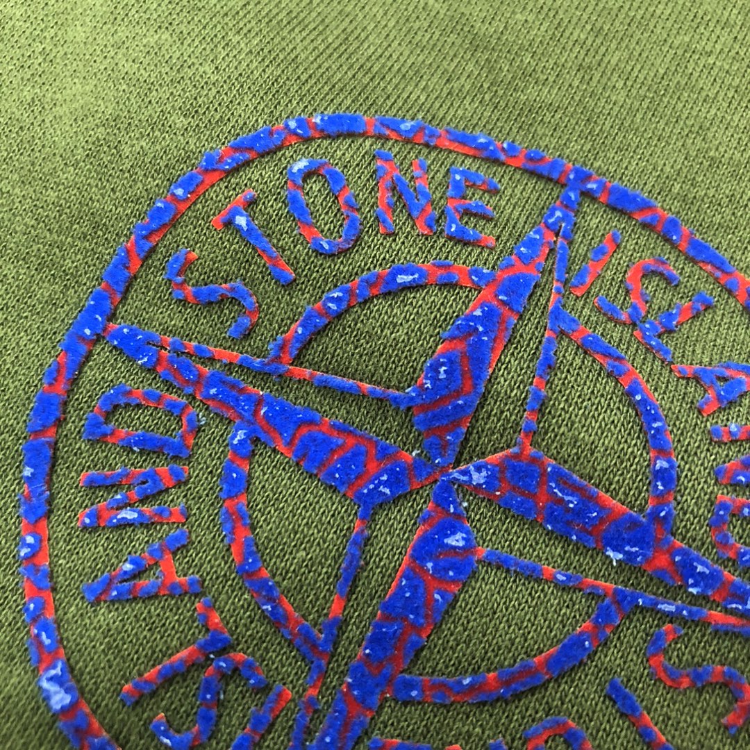 Close-up of blue logo embroidery on dark green shorts