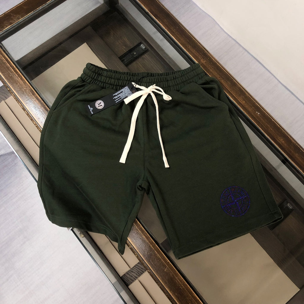 Stone Island green drawstring shorts with blue circular logo, white ties