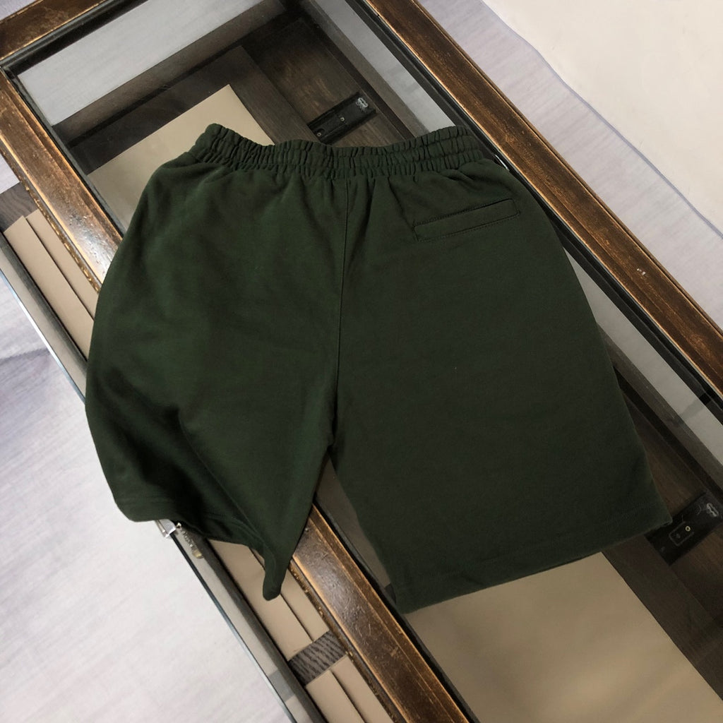 Dark green drawstring shorts on display with elastic waistband