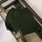 Dark green drawstring shorts on display with elastic waistband