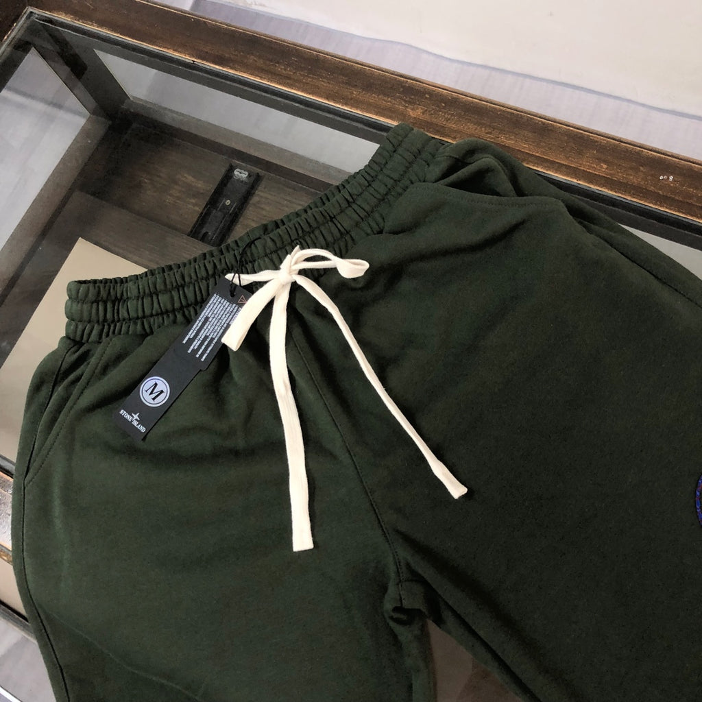 Dark green drawstring shorts with white ties and blue circular emblem