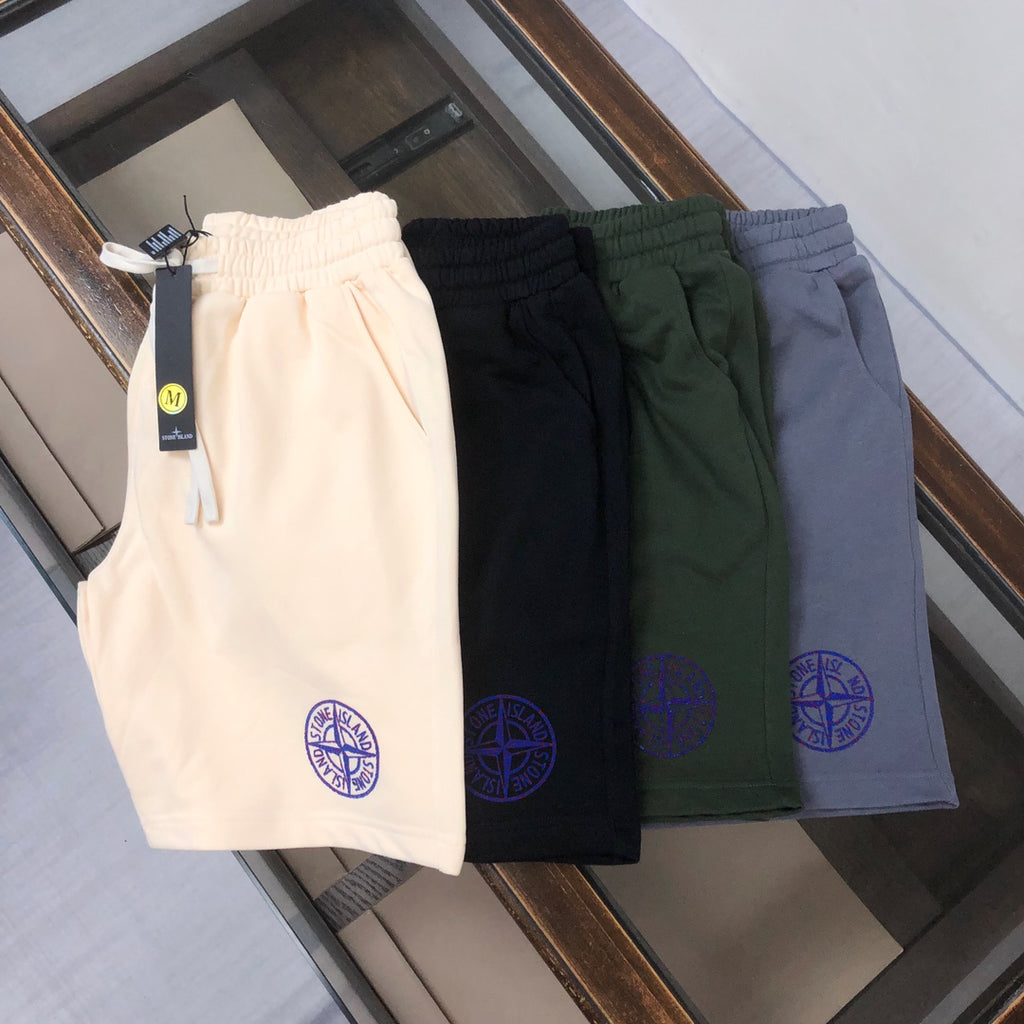 Set of four drawstring shorts in cream, black, dark green, and blue with blue logos