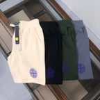 Set of four drawstring shorts in cream, black, dark green, and blue with blue logos