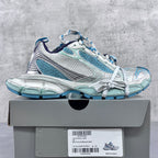 Balenciaga running shoes side view with blue mesh panels and white lace-up uppers.