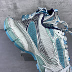 Balenciaga running shoes side angle with navy collar, teal panels, and silver overlays.