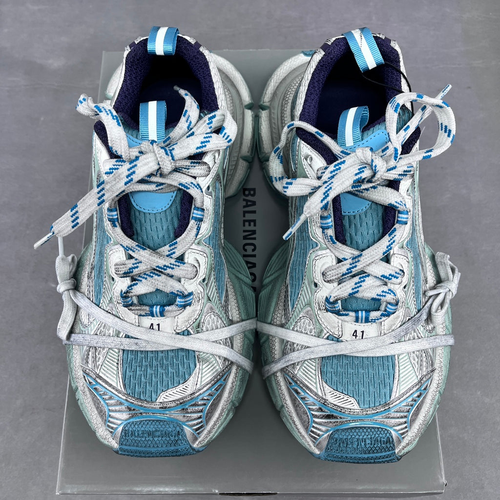 Balenciaga running shoes front view with blue lining, white laces, and patterned uppers.