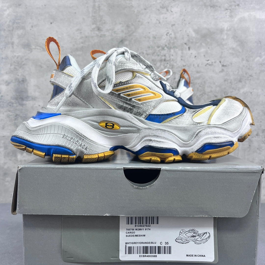 Balenciaga unisex sneakers on a shoebox: silver uppers with blue panels and gold accents.