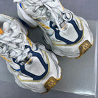 Balenciaga unisex sneaker pair close-up with laces, silver mesh, blue inserts, and gold marks.