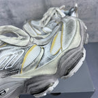 Balenciaga unisex sneaker with silver, white, and yellow trims, close-up side panel