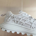 Dior unisex white sneaker upper close-up, lace-up eyelets and lattice pattern