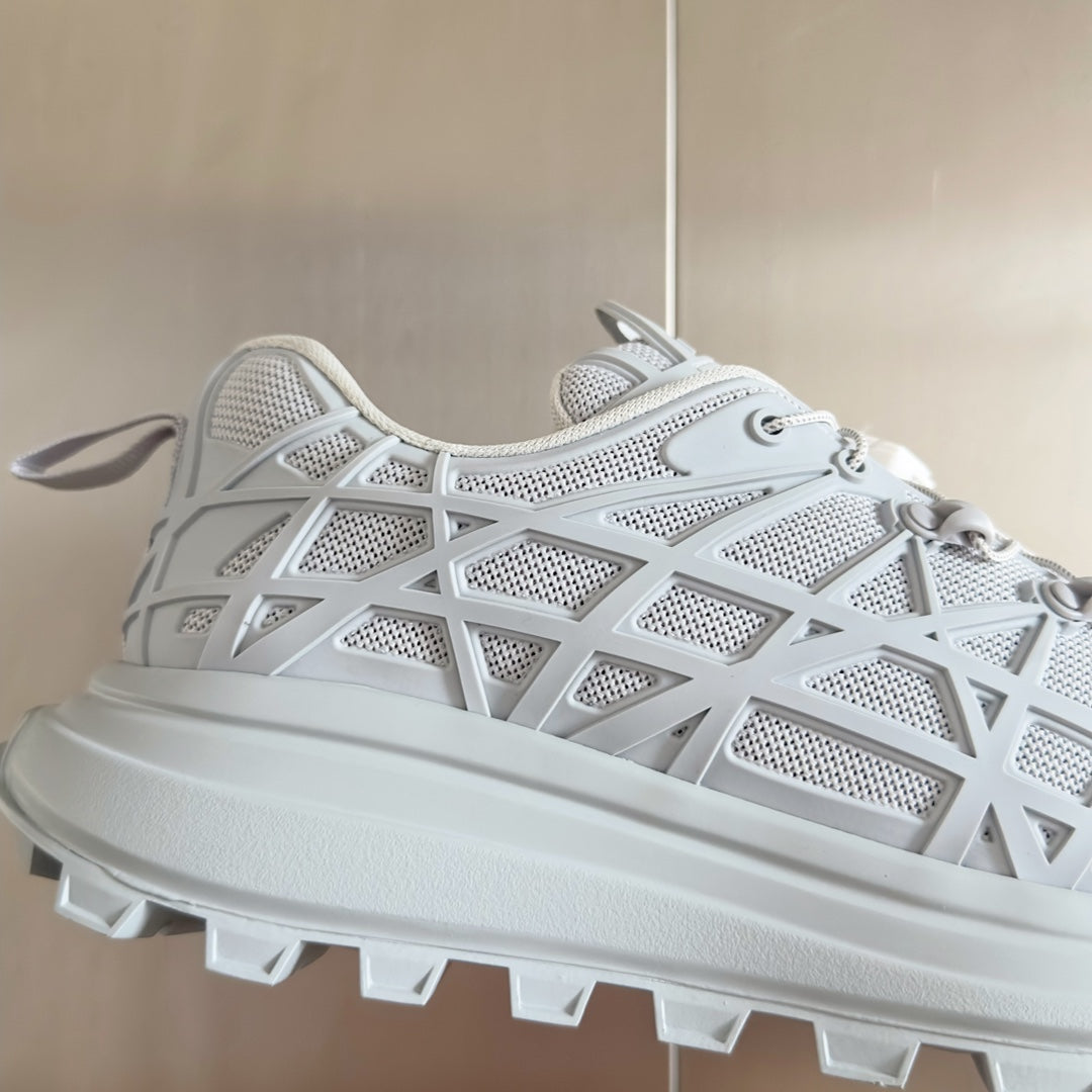 Dior unisex white sneaker upper close-up, lace-up eyelets and lattice pattern
