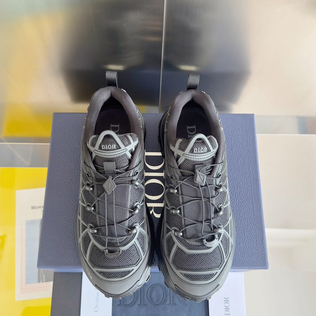 Dior unisex sneakers front view, dark gray mesh with white lattice overlay and laces