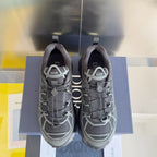 Dior unisex sneakers front view, dark gray mesh with white lattice overlay and laces