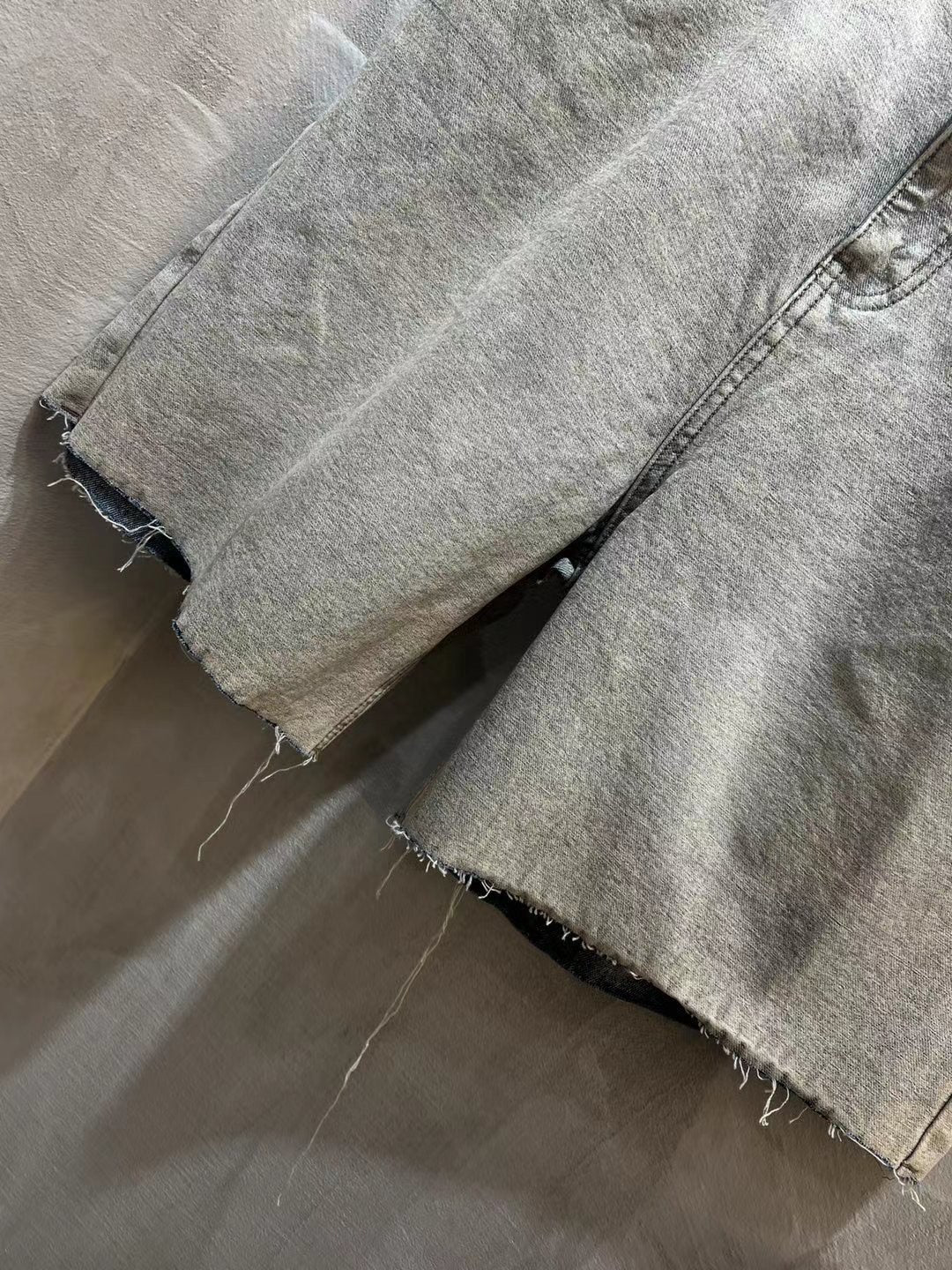 Balenciaga denim shorts close-up with frayed hem and distressed wash