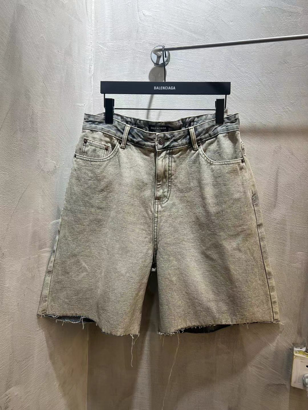 Balenciaga light-wash denim shorts with button fly, belt loops, frayed hem