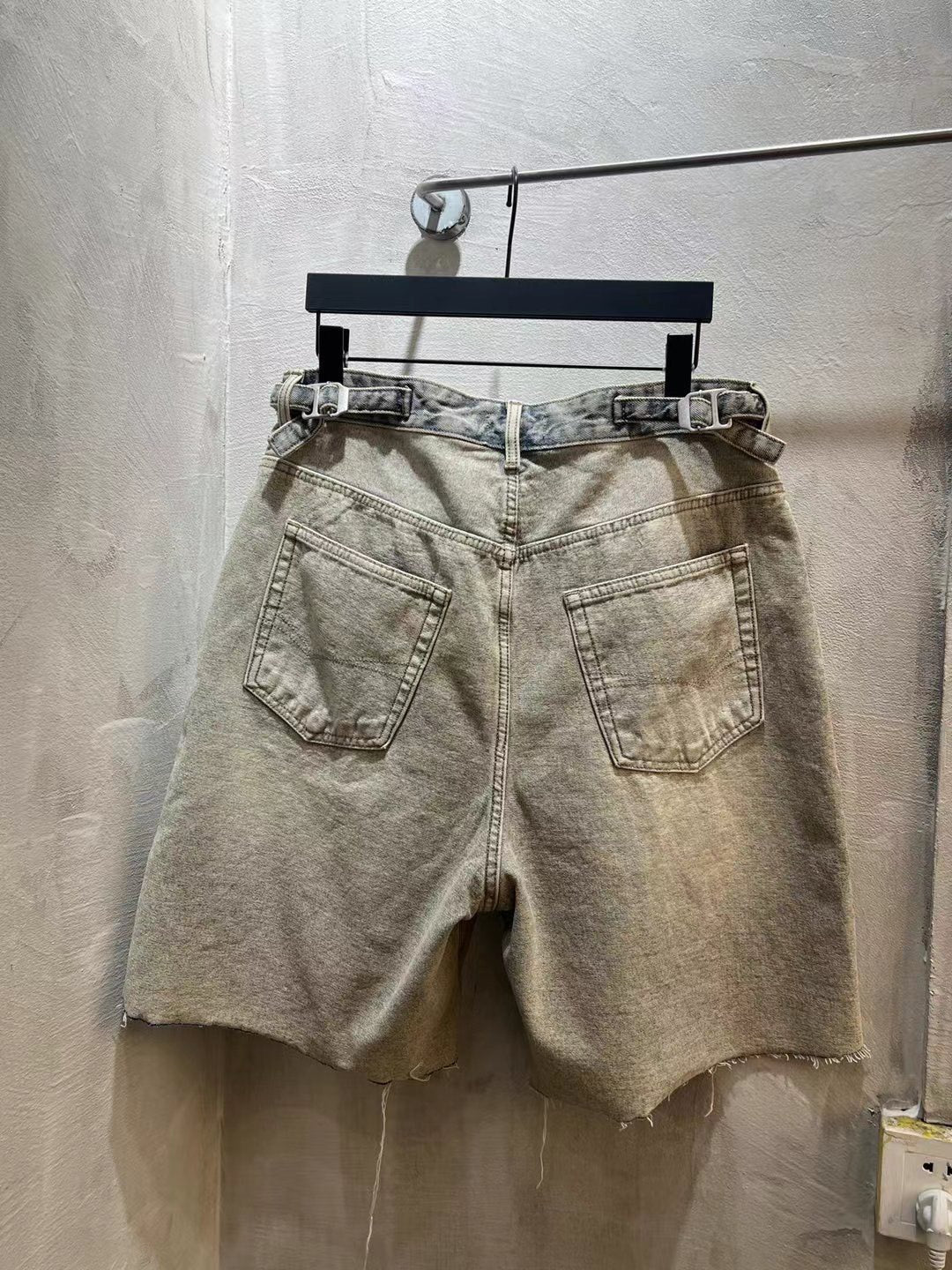 Balenciaga light-wash denim shorts with patch pockets and button fly, frayed hem