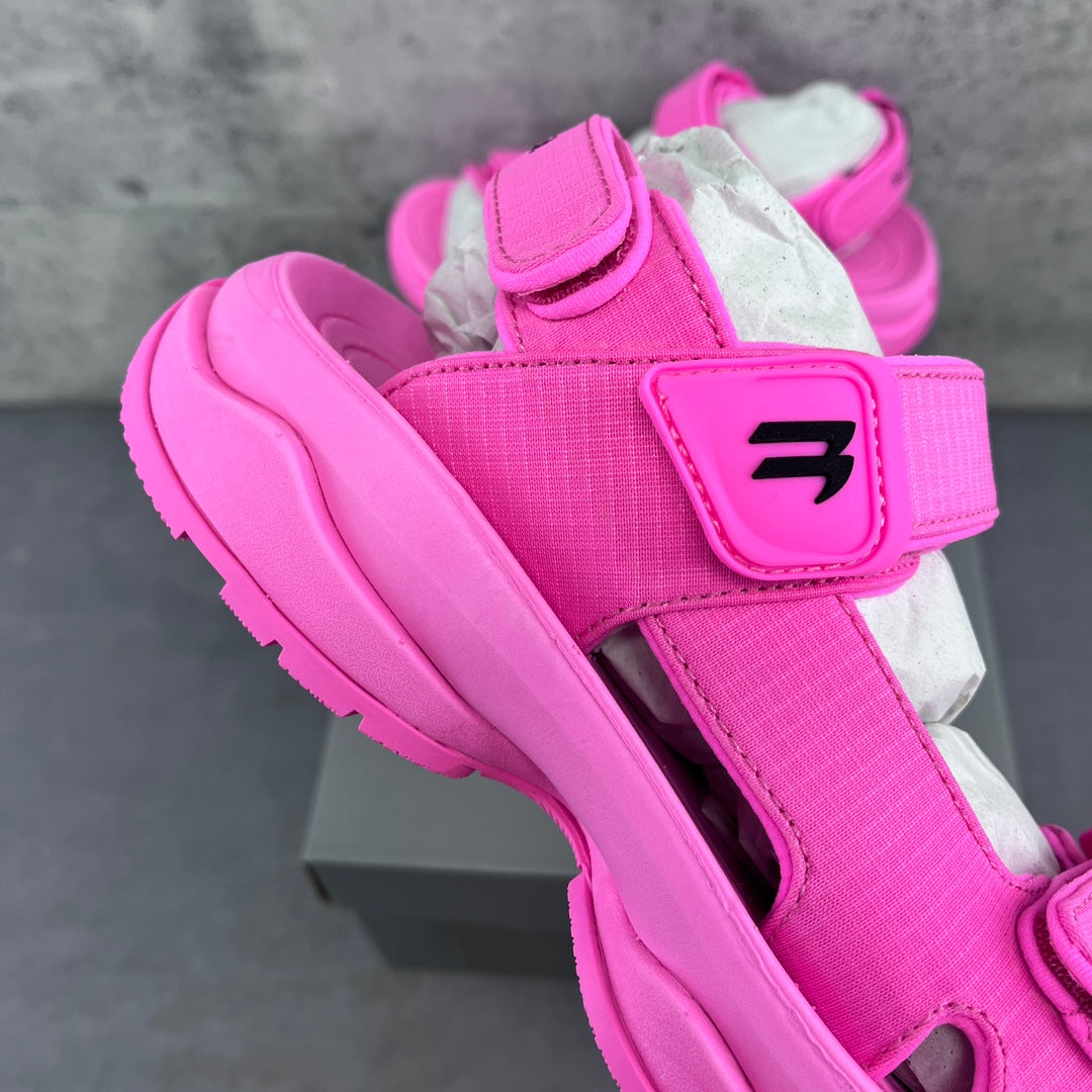 Pink Balenciaga sandal with wide strap, black logo patch, and thick platform sole