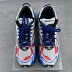 Pair of lace-up chunky sneakers with white uppers, red inserts, and blue laces.