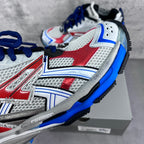 Front view of white, red and blue chunky sneakers with blue trims and mesh uppers.
