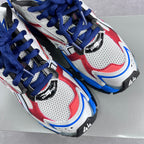 Close-up of lace-up chunky sneakers in white mesh with red panels and blue trim.