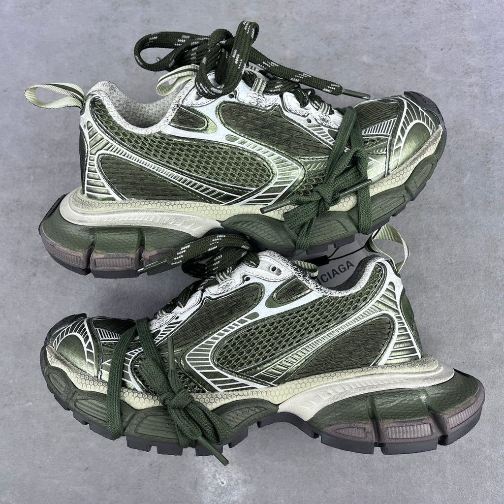 Chunky sneakers with green laces, white and silver panels, and textured mesh uppers