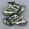 Chunky sneakers with green laces, white and silver panels, and textured mesh uppers
