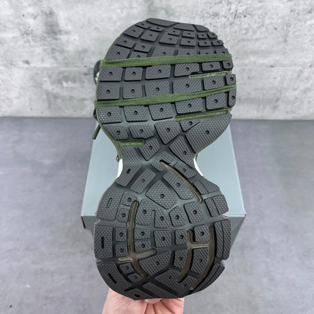Sneaker outsole with deep tread in dark gray and green accents