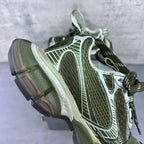 Side view sneakers with green laces, white and silver overlays, and cushioned midsole