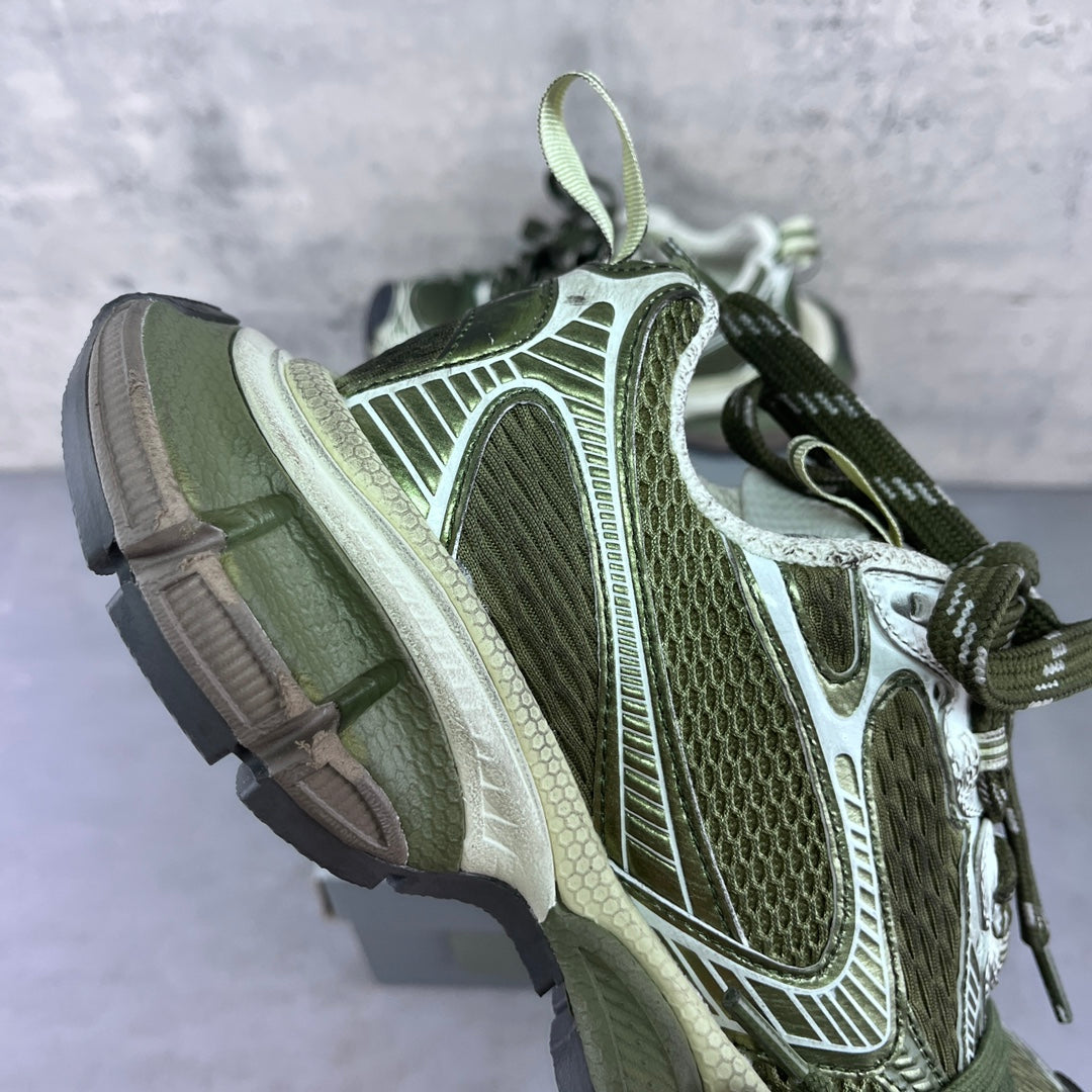 Side view sneakers with green laces, white and silver overlays, and cushioned midsole