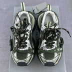 Pair of sneakers with green and black laces, white fleece lining, on a box