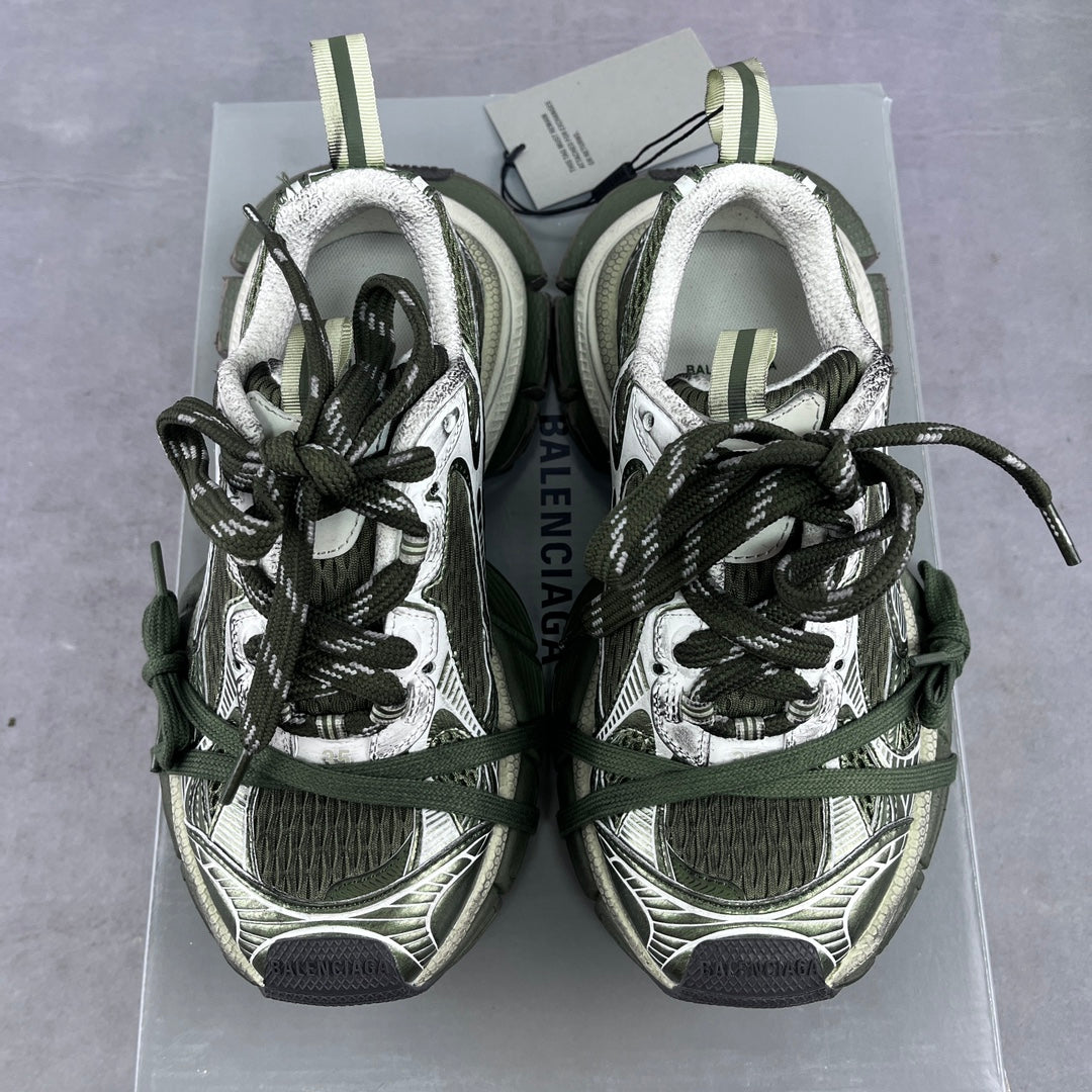 Pair of sneakers with green and black laces, white fleece lining, on a box