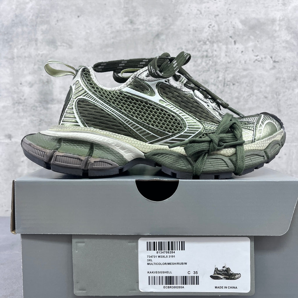Chunky sneakers on box: green lace-up with white and silver paneling, rubber sole