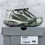 Chunky sneakers on box: green lace-up with white and silver paneling, rubber sole
