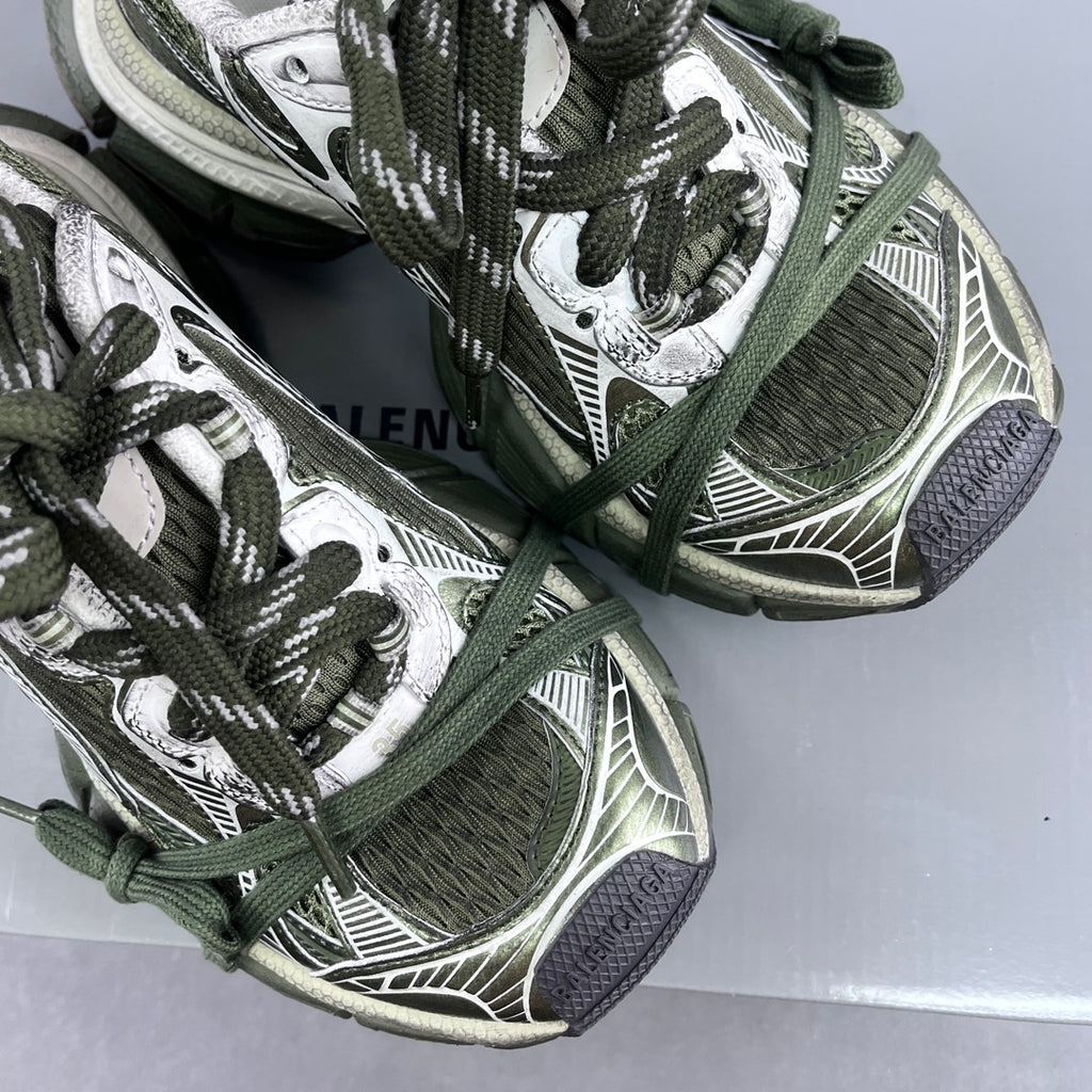 Detailed view of sneakers: green laces over patterned mesh and white logo-style panels
