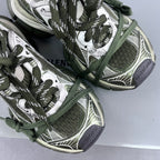 Detailed view of sneakers: green laces over patterned mesh and white logo-style panels