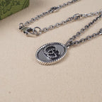 Silver chain necklace with oval logo pendant close-up