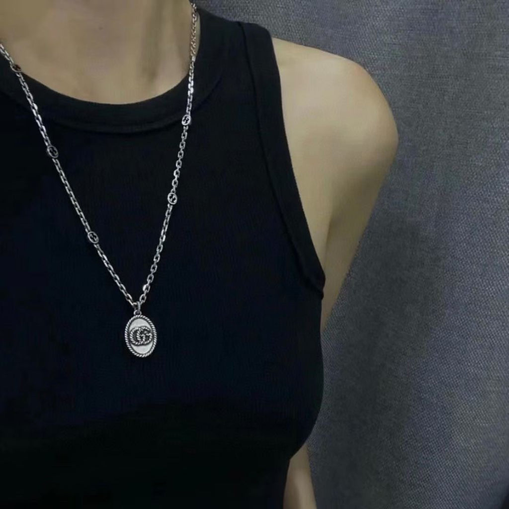 Silver chain pendant necklace on black sleeveless top