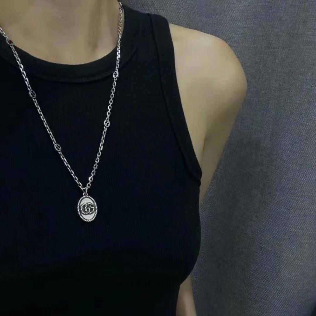 Silver chain pendant necklace on black sleeveless top