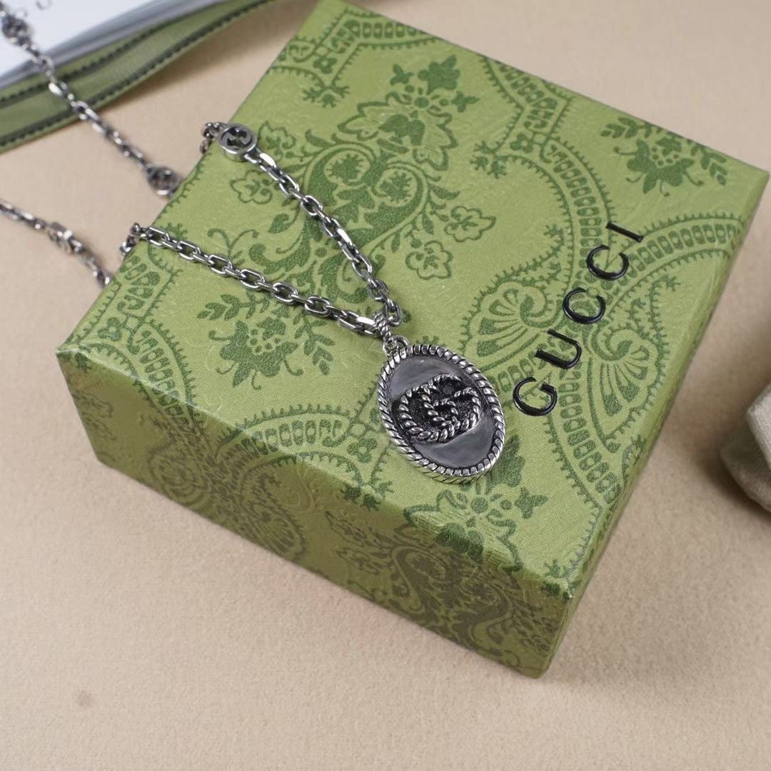 Silver chain necklace with round oval logo pendant