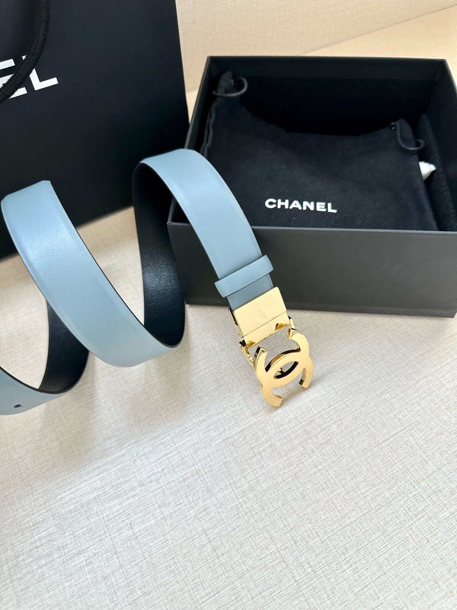 Light blue leather belt with gold-toned Chanel CC buckle and wide strap