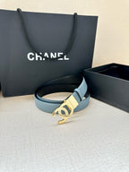 Light blue leather belt with gold-toned Chanel CC buckle lying flat