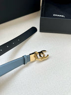 Light blue leather belt end with gold-toned buckle and metal adjustment holes