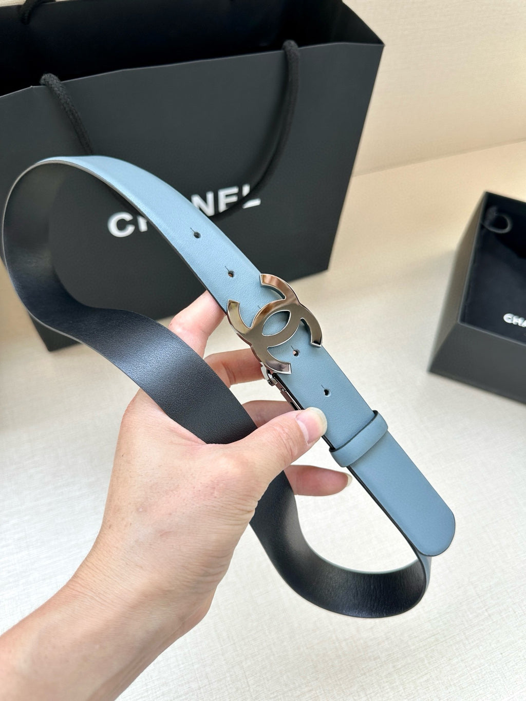 Light blue leather belt with Chanel CC buckle and metal prong detail