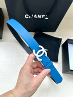 Blue leather belt with silver CC logo buckle, held in hand