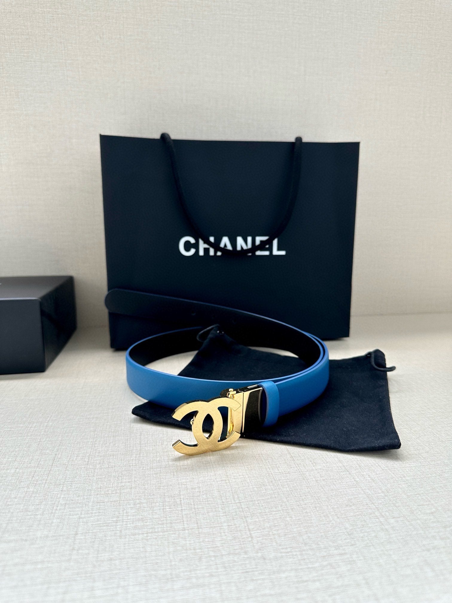 Blue leather belt with gold-tone CC buckle and small pouch